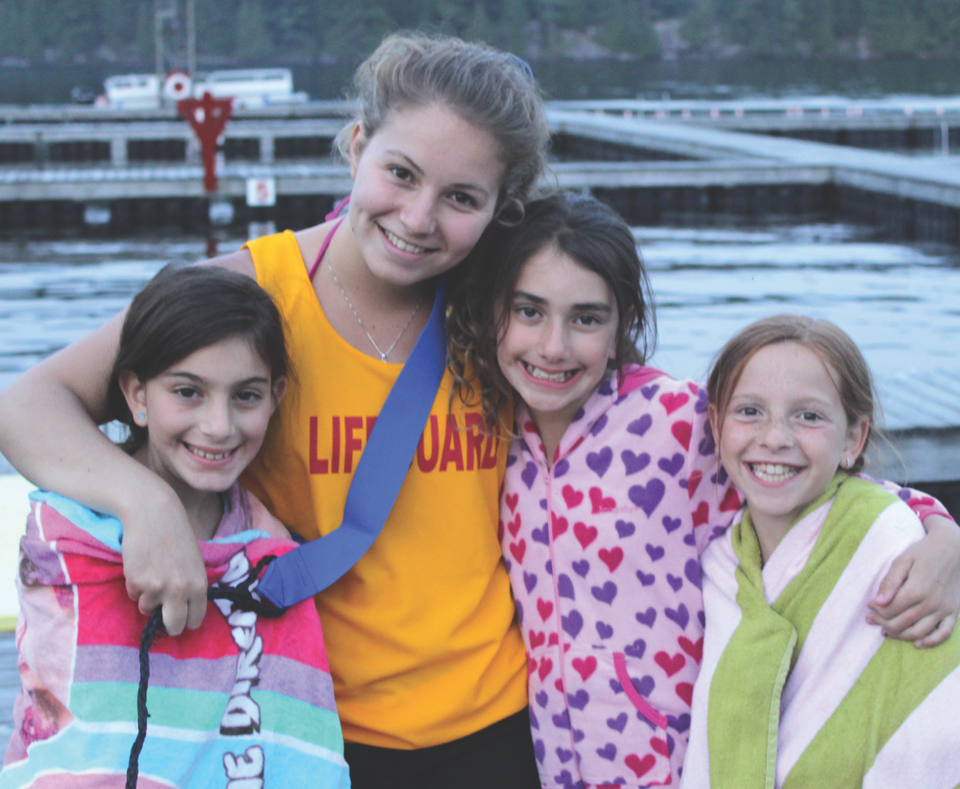 Four girls posing for a photograph with their arms around each other