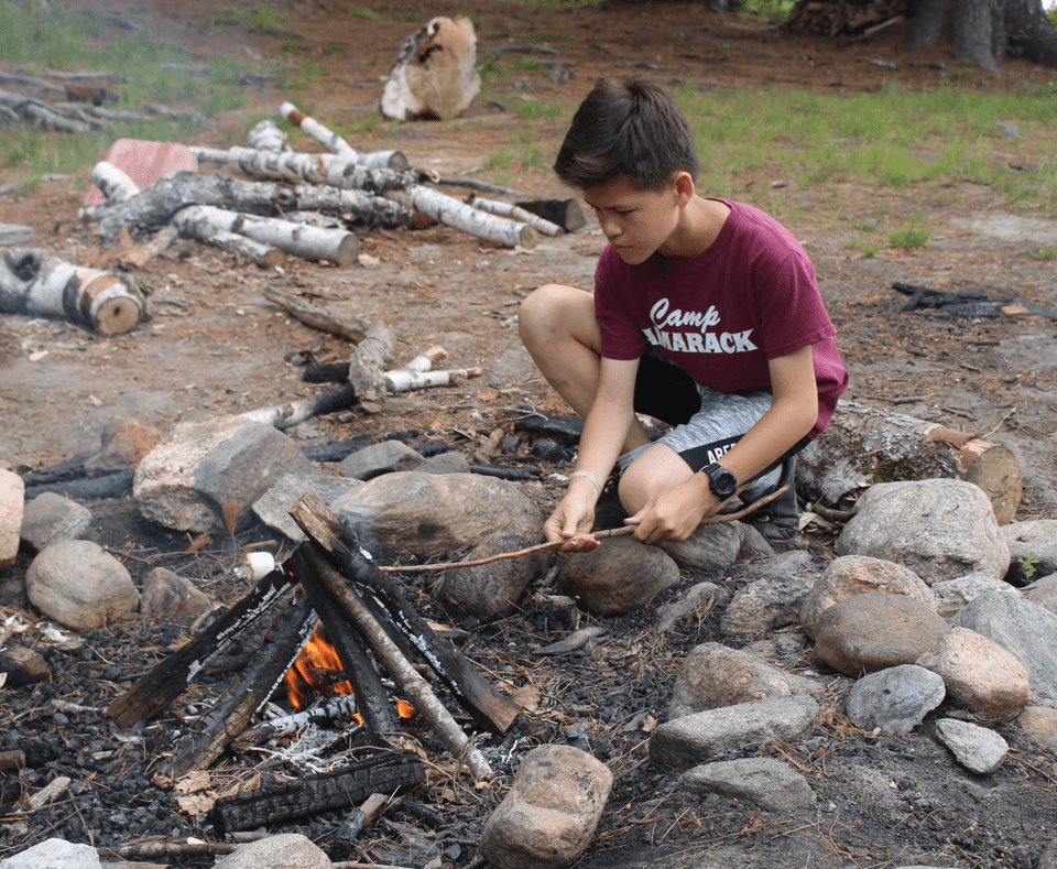Camper building a fire at Camp Tamarack