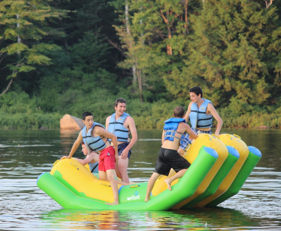 Campers on a flotation device on the lake