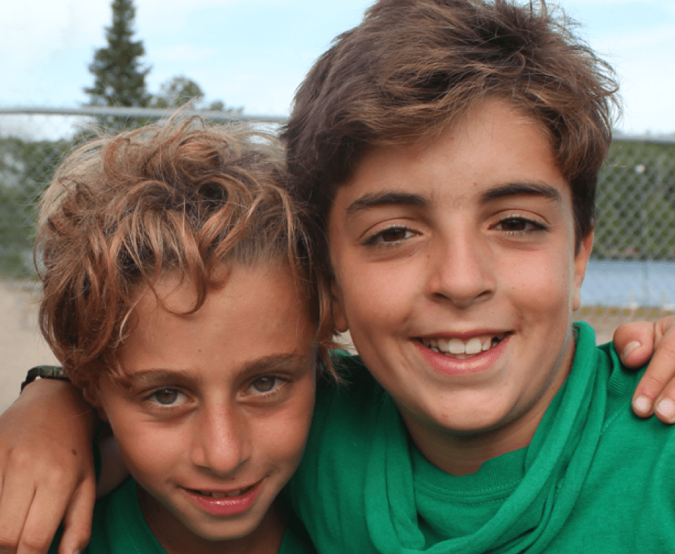 Three boys wrapping arms around each other and posing for a photo