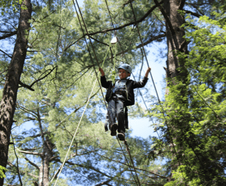 Boy doing ropes course at Camp Tamarack